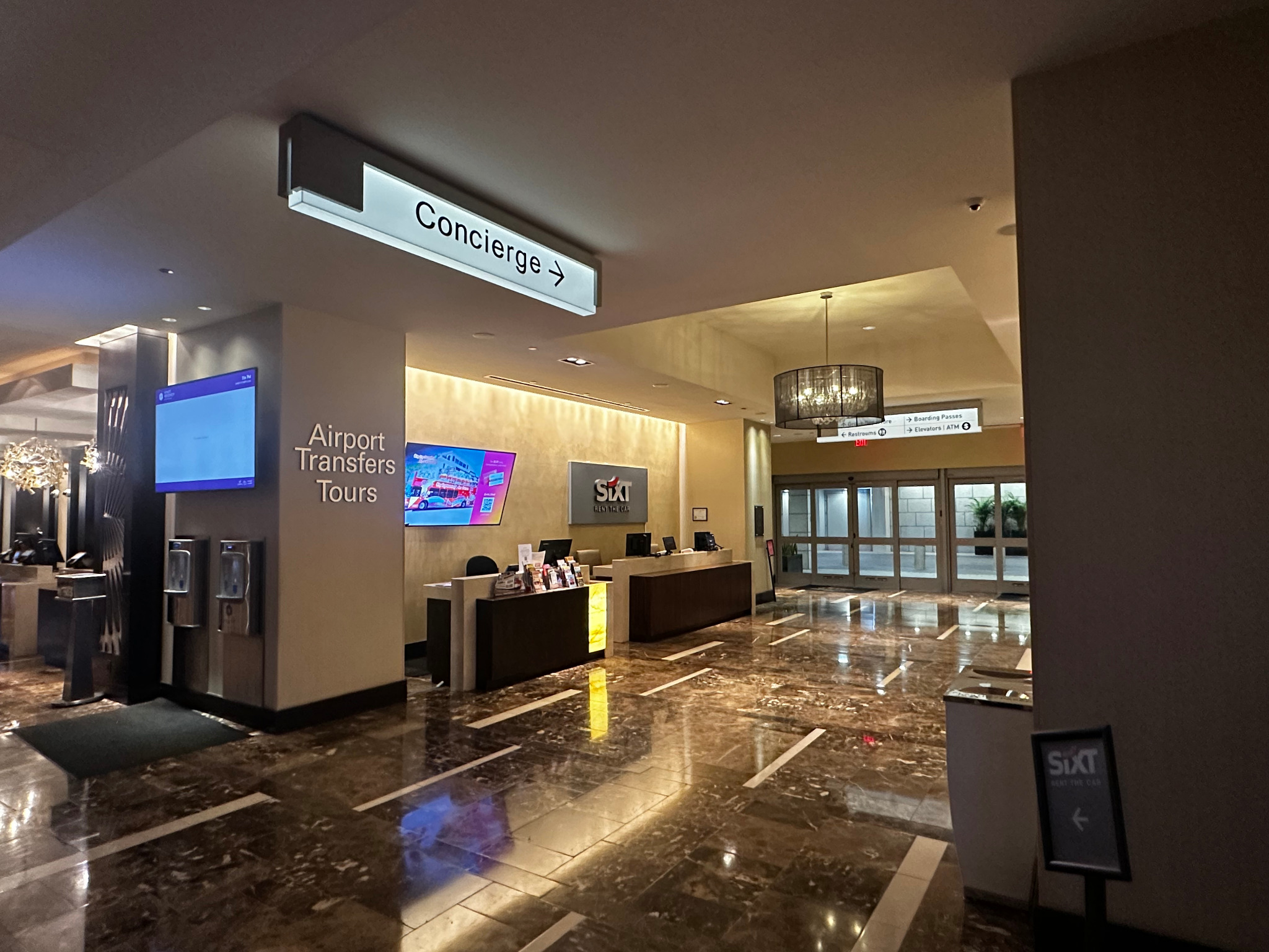 Hyatt Regency New Orleans Concierge Lobby meeting spot, marked by the overhead Concierge sign beside the Airport Transfers and Tours desk.
